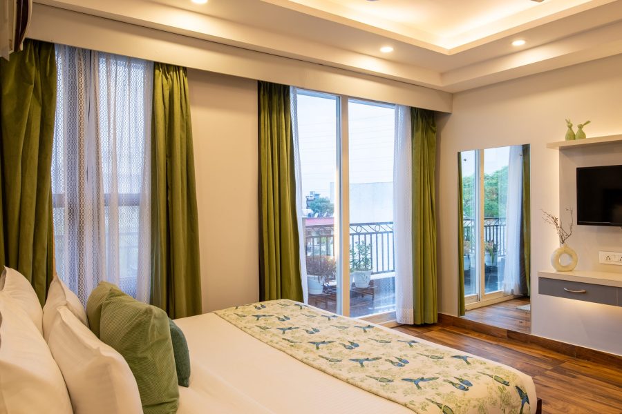 Bedroom with balcony view in 2 BHK at Bedchambers Service Apartment Sector 38 Gurgaon
